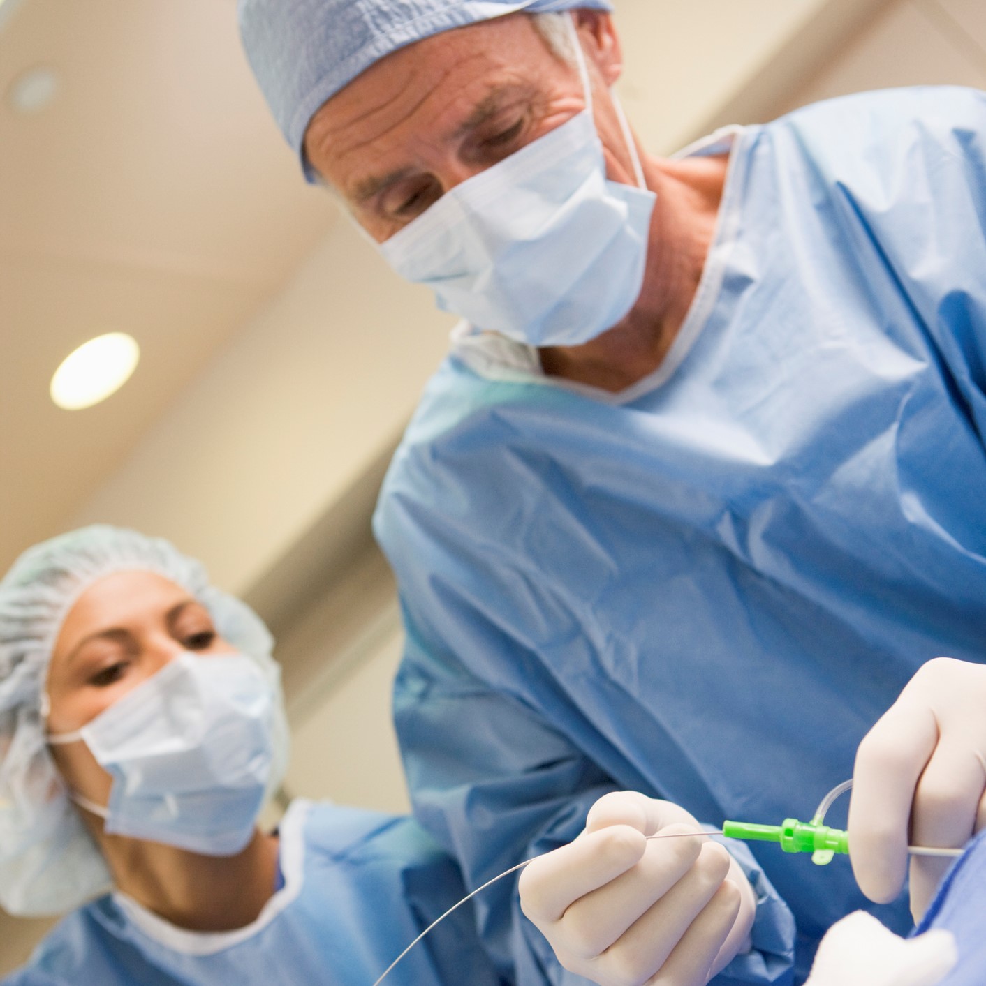 Surgeons Preparing Equipment For Surgery Surgeons Preparing Equipment For Surgery Helping Each Other In Operating Theatre