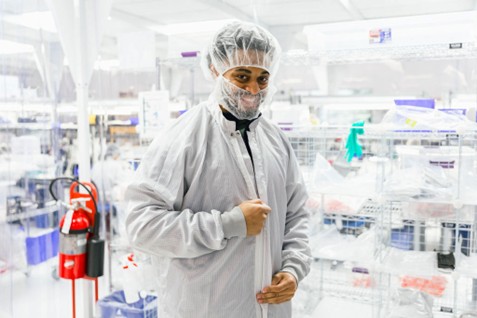 Medical device manufacturing technician in full protective gear